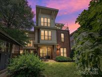 Striking modern home with a mix of brick and siding, plus a rooftop deck at sunset at 956 Warren Burgess Ln, Charlotte, NC 28205