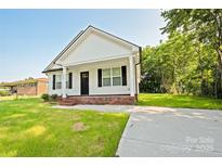 Charming single-story home with white siding, black shutters, and a welcoming front porch at 1028 Gibson St, Albemarle, NC 28001