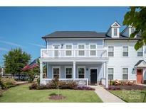 Charming two-story home featuring a covered front porch, second floor deck, and manicured lawn with American flag at 1100 Herrons Ferry Rd, Rock Hill, SC 29730