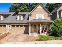 Charming two-story home featuring a covered front porch, brick driveway, and a two-car garage at 128 Aztec Cir, Mooresville, NC 28117