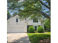 Charming two-story home with a two-car garage, manicured lawn, and mature tree at 13039 Peacock Ln, Charlotte, NC 28215