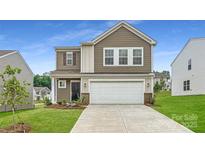 Charming two-story home boasts a two-car garage, manicured lawn, and welcoming front entrance at 146 Astor St, Troutman, NC 28166