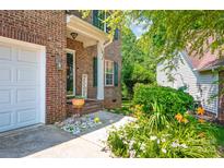 Charming brick home featuring a welcoming front porch with beautiful landscaping and a 'Welcome' sign at 167 Foxtail Dr, Mooresville, NC 28117