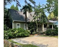 Charming home featuring a cozy front porch and lush, mature landscaping in a desirable neighborhood at 1701 Truman Rd, Charlotte, NC 28205