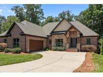 Beautiful brick house with manicured lawn, 2-car garage and covered front porch at 2341 Shiny Leaf Dr, Denver, NC 28037