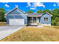 Charming home featuring an attached garage, light blue siding, and a well-manicured front lawn at 338 Hollingswood Dr, Statesville, NC 28625