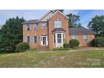 Charming two-story brick home with gray shutters, a bay window, and a well-maintained front lawn at 4227 Kiser Woods Sw Dr, Concord, NC 28025