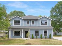Charming two-story home with blue siding, manicured lawn, and black trim windows at 428 Clay St, Mooresville, NC 28115