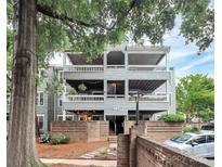 Multi-level condo building with balconies, brick accents, mature trees, and parking at 433 W 8Th Street St, Charlotte, NC 28202