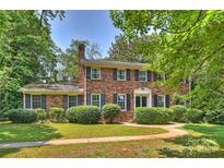 Charming two-story brick home featuring mature landscaping and black window shutters at 6434 Sardis Rd, Charlotte, NC 28270