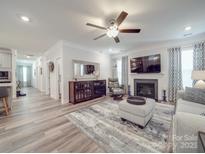 Bright living room with fireplace, ceiling fan, wood floors, and comfortable seating area at 647 R L Stowe Rd, Belmont, NC 28012