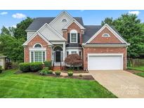 Charming two-story brick home with well-manicured lawn and attached two-car garage at 6632 Hawksnest Dr, Charlotte, NC 28269