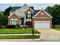 Charming brick home with a well-manicured lawn, attached two-car garage, and inviting front entrance at 6632 Hawksnest Dr, Charlotte, NC 28269