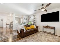 Inviting living room features a ceiling fan, decorative rug and a brown leather sofa with accent pillows at 925 Skywatch Ln, Monroe, NC 28112