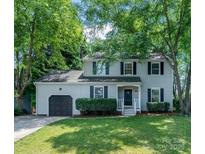 Charming two-story home with a well-manicured lawn, lush greenery, and inviting curb appeal at 9513 Saddle Run Trl, Charlotte, NC 28269