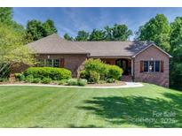Charming brick home featuring a manicured lawn, lush landscaping, and a welcoming walkway to the front entrance at 103 3Rd Sw St, Catawba, NC 28609