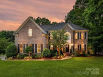 Beautiful two-story brick home with lush landscaping and a well-manicured lawn at 105 Beech Bluff Dr, Mount Holly, NC 28120