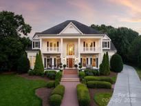 Stunning two-story home featuring classic columns, symmetrical design, and manicured landscaping at 11723 Oakland Hills Pl, Charlotte, NC 28277