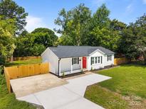 Charming single-story home with a bright red door, manicured landscaping, and a newly paved driveway at 1319 Mt Gallant Rd, Rock Hill, SC 29732