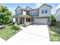 Inviting two-story home featuring a well-manicured lawn and a spacious two-car garage at 15018 Marymont Ave, Huntersville, NC 28078