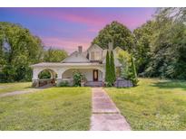Charming two-story home with landscaped yard and inviting front porch with beautiful color sky at 1637 N College Ave, Newton, NC 28658