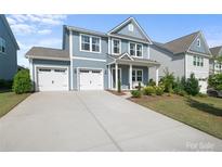 Charming two-story home with a two-car garage, landscaped yard, and covered front porch at 1826 Goodheart Ln, York, SC 29745