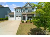 Charming two-story home boasts a two-car garage, manicured lawn, and inviting front porch at 1826 Goodheart Ln, York, SC 29745