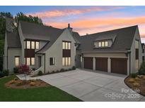 Stunning painted-brick home featuring a three-car garage and meticulous landscaping at 213 Crest Ct, Weddington, NC 28104