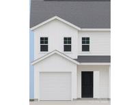 Newly constructed two-story home featuring white siding, black front door and a two car garage at 2735 Primrose Ave, Charlotte, NC 28208