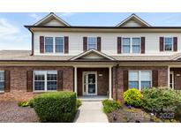 Charming townhouse featuring brick facade, symmetrical windows, and manicured landscaping at 2765 Clover Nw Rd, Concord, NC 28027