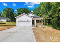 Charming white house with a one-car garage, a cozy front porch, and a long concrete driveway at 332 Hollingswood Dr, Statesville, NC 28625
