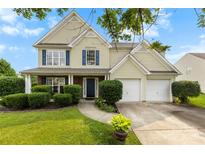 Charming two-story home with a well-manicured lawn, blue shutters, and a two-car garage at 4612 Maple Crest Pl, Harrisburg, NC 28075