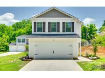 Two-story home featuring a two-car garage with white doors and black hardware and a well-maintained front yard at 463 W Barr St, Lancaster, SC 29720
