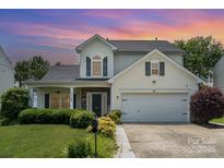 Charming two-story home featuring manicured lawn, stone accents, and attached two car garage at 5723 Lindley Crescent Dr, Indian Trail, NC 28079