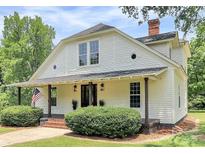 Charming two-story home with a covered porch, American flag, and manicured bushes at 604 Ferguson Ridge Rd, Gastonia, NC 28052