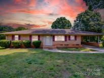 Charming brick home with well-manicured lawn and covered carport at 6416 Wilgrove Mint Hill Rd, Mint Hill, NC 28227