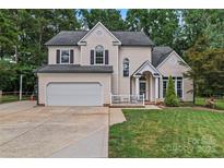 Charming two-story home featuring a well-manicured lawn, two-car garage, and inviting front porch at 107 Glenmont Ct, Mooresville, NC 28117