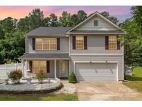 Charming two-story home with landscaped yard, white fence and fountain feature enhancing curb appeal at 10816 Pointer Ridge Dr, Charlotte, NC 28214