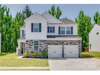 Charming two-story home featuring a stone facade, white siding, and a two-car garage at 1195 Cavalier Ln, Rock Hill, SC 29730