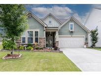 Charming home featuring stone accents, well-manicured lawn, flower beds, and a two-car garage at 132 Hillston Ln, Mooresville, NC 28115