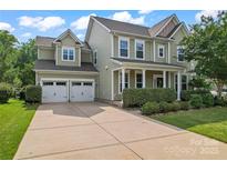 Traditional two-story home with a two-car garage, front porch and well-manicured landscaping at 133 Yellowbell Rd, Mooresville, NC 28117