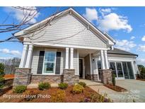 Charming home with stone accents, covered porch, manicured landscaping, and an attached two car garage at 1432 Ardmore Dr # 341, Sherrills Ford, NC 28673