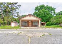Charming single-story home with a covered front porch and neutral-colored siding, nestled among mature trees at 1529 Stony Point Rd, Shelby, NC 28150