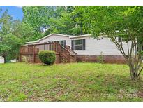 Charming single-story home featuring a wooden deck and lush greenery surrounding the property at 1773 Baldwin Ln, Lincolnton, NC 28092