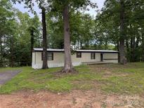 Exterior view of manufactured home with a brown roof, siding, and trees surrounding the home at 326 Havencrest Ct, Gastonia, NC 28052