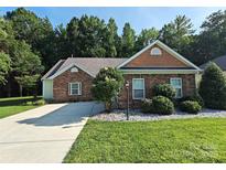 Charming single-story home with brick accents, well-manicured lawn, and mature landscaping at 509 Settlers Grove Ln, Salisbury, NC 28146
