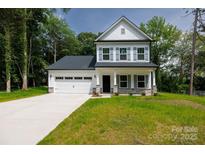 Charming two-story home with a two car garage, stone accents, and a well manicured front lawn at 512 Beverly Cir, Charlotte, NC 28270