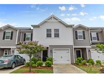 Charming townhome featuring a light gray exterior, an attached garage, and a small tree in the front yard at 524 Tayberry Ln, Fort Mill, SC 29715