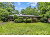 Charming single-story brick home with a covered carport and a well-maintained, green lawn at 6207 Robinson Church Rd, Charlotte, NC 28215