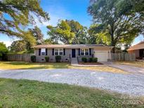 Charming home with a gravel driveway, complemented by lush trees, offering a welcoming curb appeal at 6208 Charlie Walker Rd, Kannapolis, NC 28081